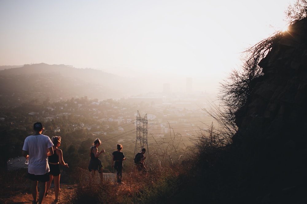 photo of five people walking down on pathway