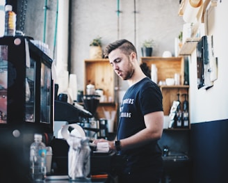 shallow focus photography of man using cash register inside counter area