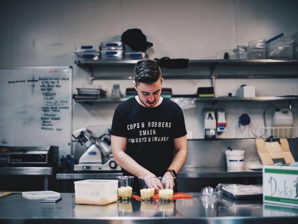 homme en chemise noire à côté de la table de cuisine