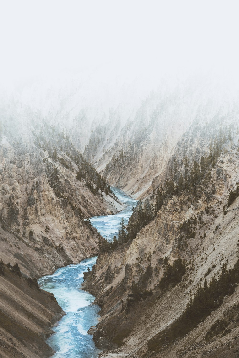 Fluss zwischen Bergen unter weißen Wolken