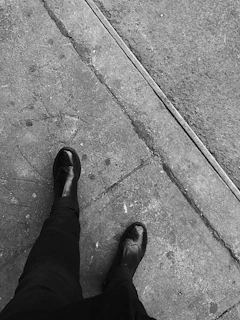 A candid shot of streetwear shoes stepping on a cracked pavement with shadows playing around