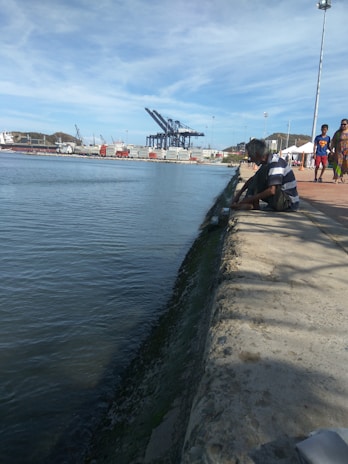 A confident businessperson reviewing shipping documents by the waterfront.