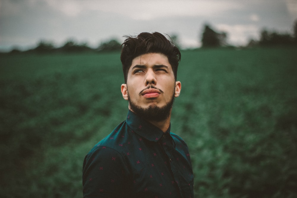 man focus photography of man in green collared top