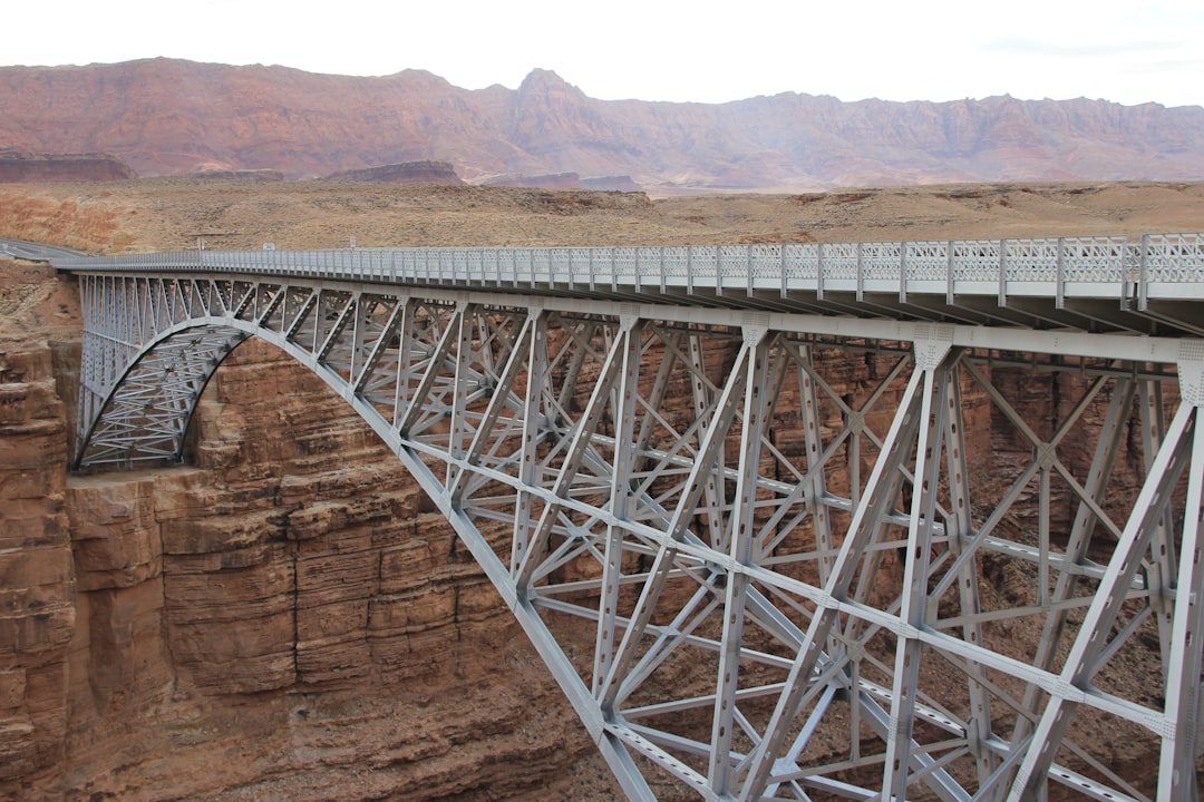 white metal bridge over brown mountain