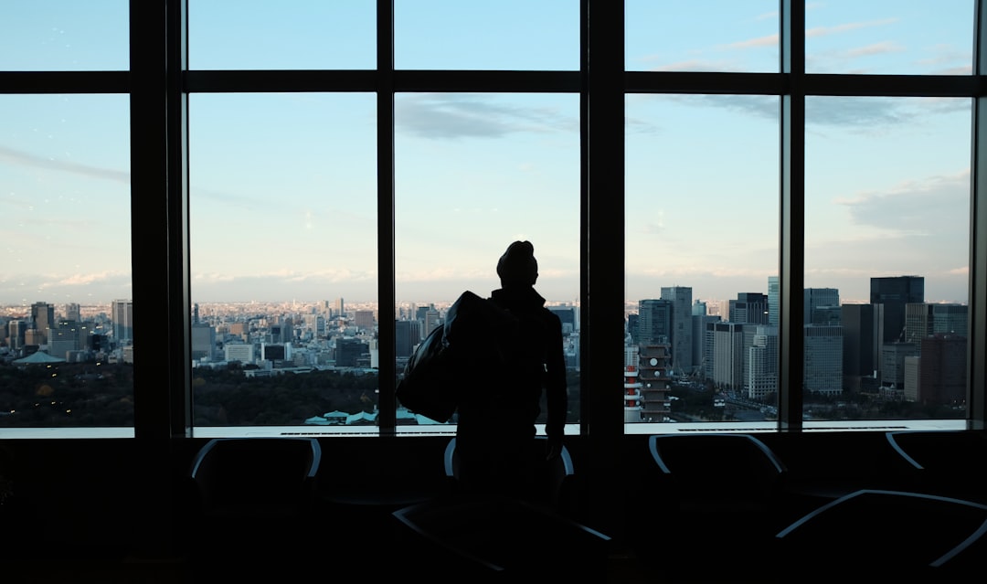 silhouette of person looking to glass window, Staring out building windows