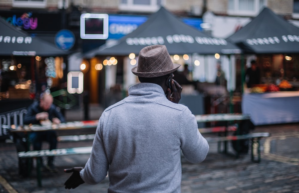 shallow focus photography of man walking in front of establishments