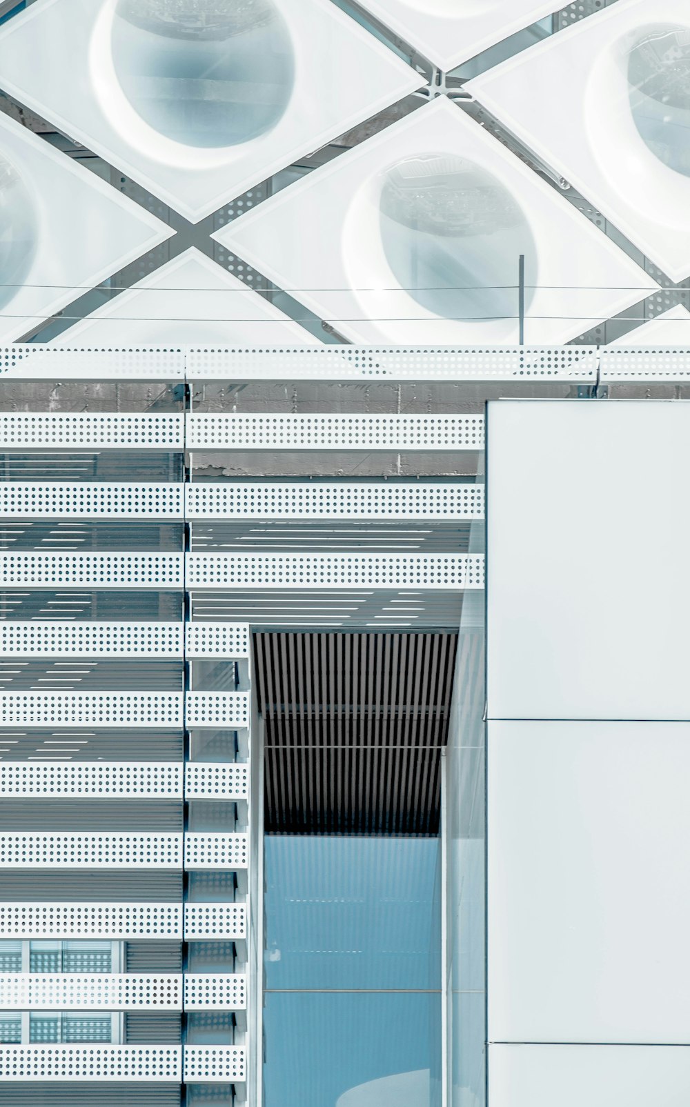 The exterior of an office building in Madrid with a glass door and geometric shapes on the facade