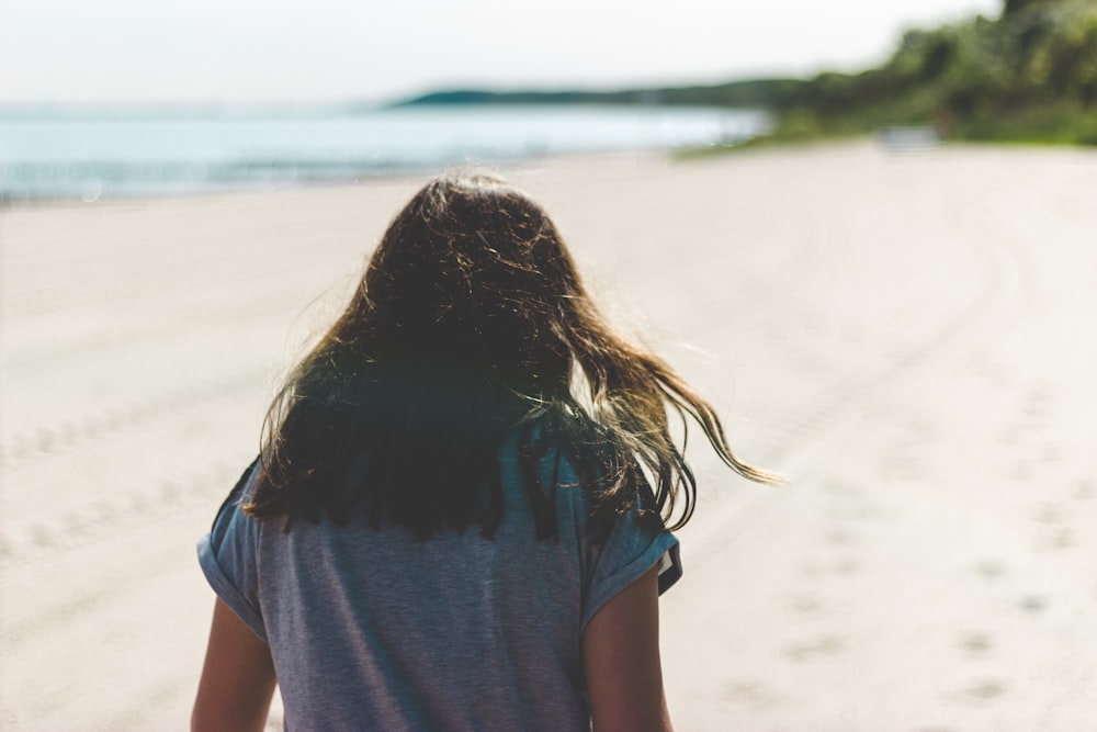 woman walking in seashore during daytime