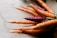 Close-up of vibrant baby carrots bundled together on a rustic wooden table.