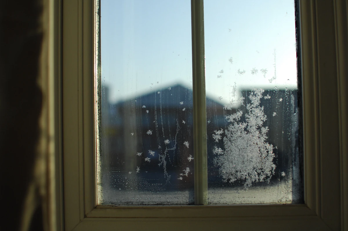 Frost on a window looking out to a neighboring house