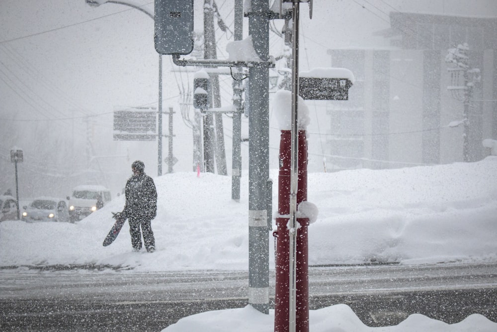 photo of man standing while holding board near road