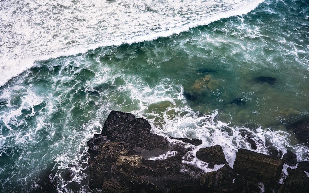 Photographie à vol d’oiseau de rochers à côté d’un plan d’eau