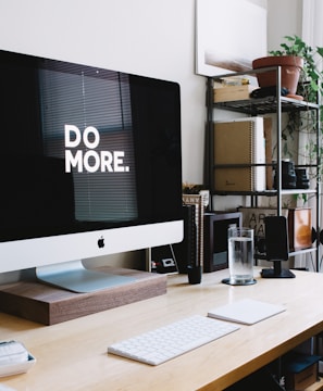 silver iMac with keyboard and trackpad inside room