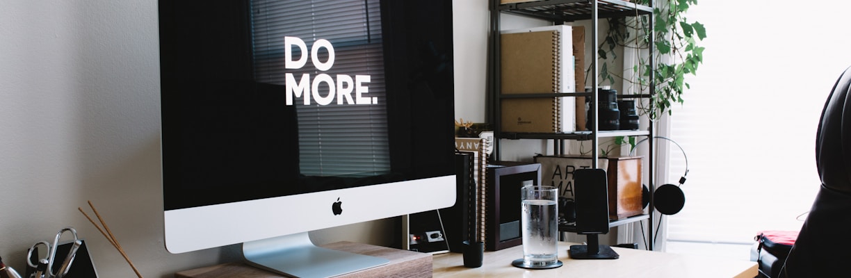 silver iMac with keyboard and trackpad inside room