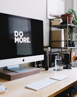 silver iMac with keyboard and trackpad inside room