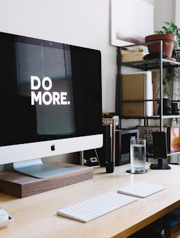 silver iMac with keyboard and trackpad inside room