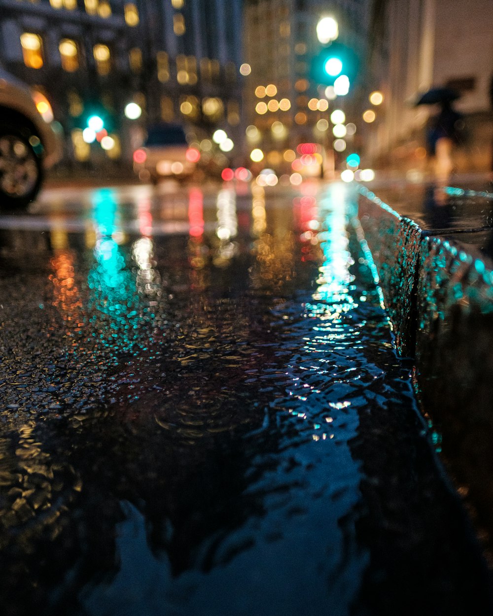 Une image nocturne capturant la pluie au sol dans une rue du centre-ville.