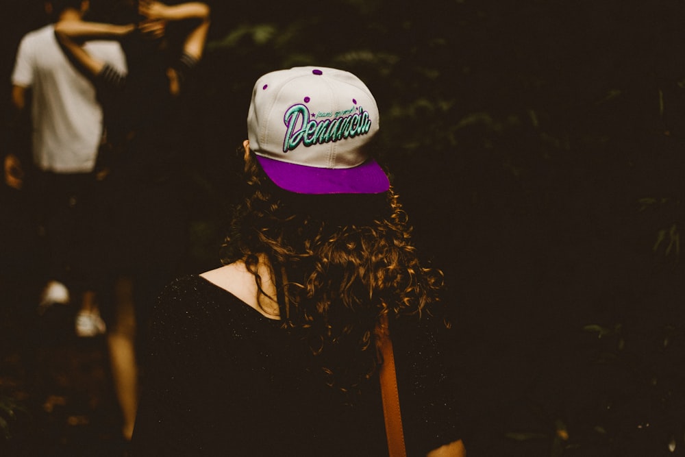 woman wearing white and purple fitted cap