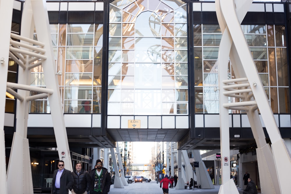 people walking under glass commercial building