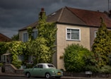 green and white coupe parked outside the house