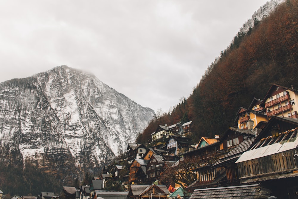 white and brown mountains near houses under gray sky during daytime