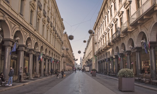 people walking between buildings during daytime in Piazza Castello Italy