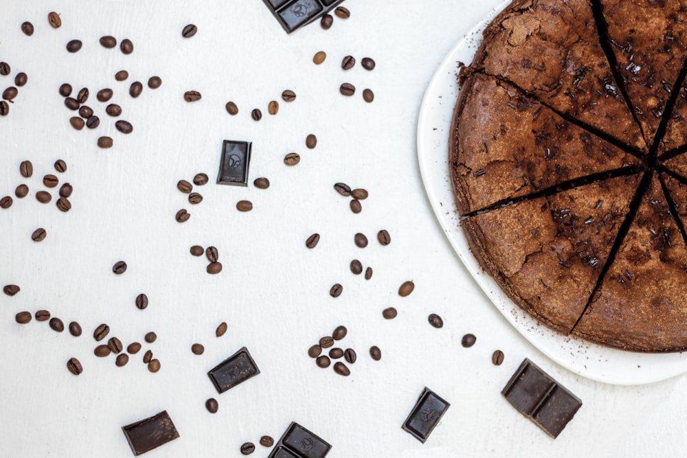 chocolate negro cerca de pastel de chocolate en rodajas y granos de café