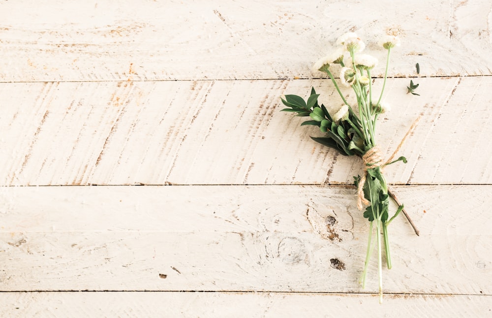 white flower bouquet on wooden surface