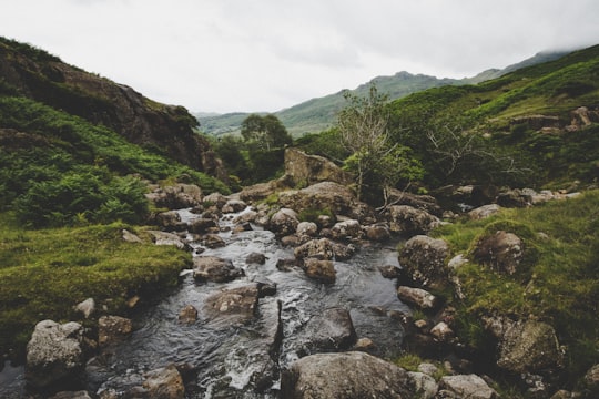 brown rock formation beside green grass during daytime in Lake District National Park United Kingdom