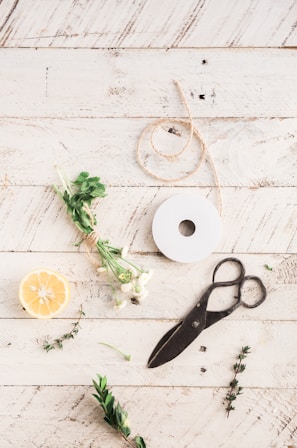 A vintage left-handed scissors resting on a wooden desk with scattered sketches.