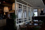 Cozy cafe interior using PDLC smart film on glass partitions to create intimate seating zones.
