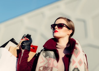 shallow focus photography of woman holding shopping bags during day