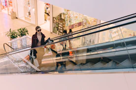 woman riding escalator