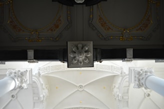 Close-up of refined architectural details in black and gold tones against white background.
