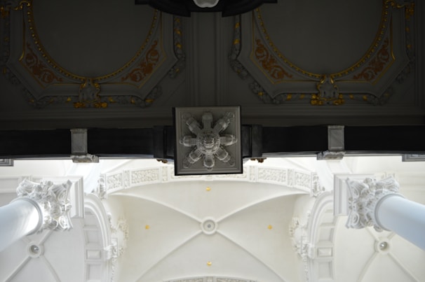 Close-up of refined architectural details in black and gold tones against white background.