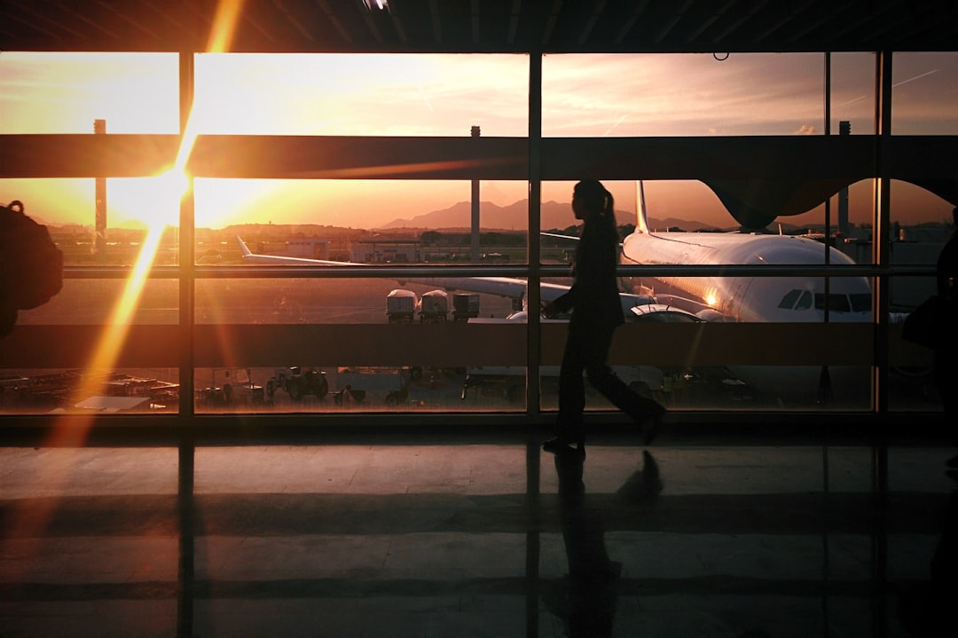 silhouette of person walking beside airplane