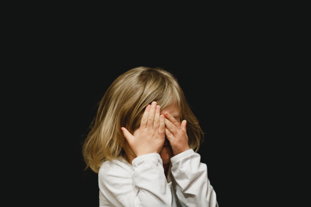 girl covering her face with both hands