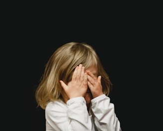 girl covering her face with both hands