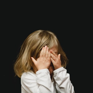 girl covering her face with both hands