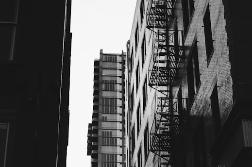 A dramatic urban scene featuring bold monochrome colors with a touch of deep red.