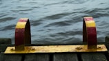 Close-up of a wooden dock with mooring cleats and calm water reflections.