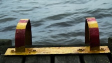 Close-up of a wooden dock with mooring cleats and calm water reflections.