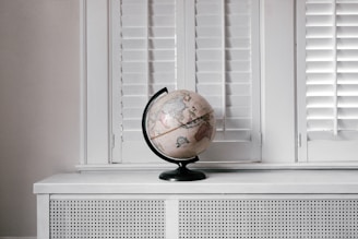 beige desk globe on white desk