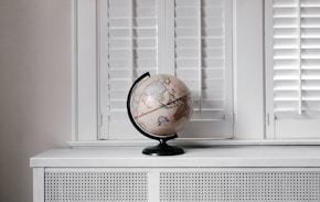 beige desk globe on white desk by Andrew Neel (https://unsplash.com/@andrewtneel)