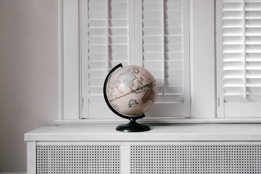 beige desk globe on white desk