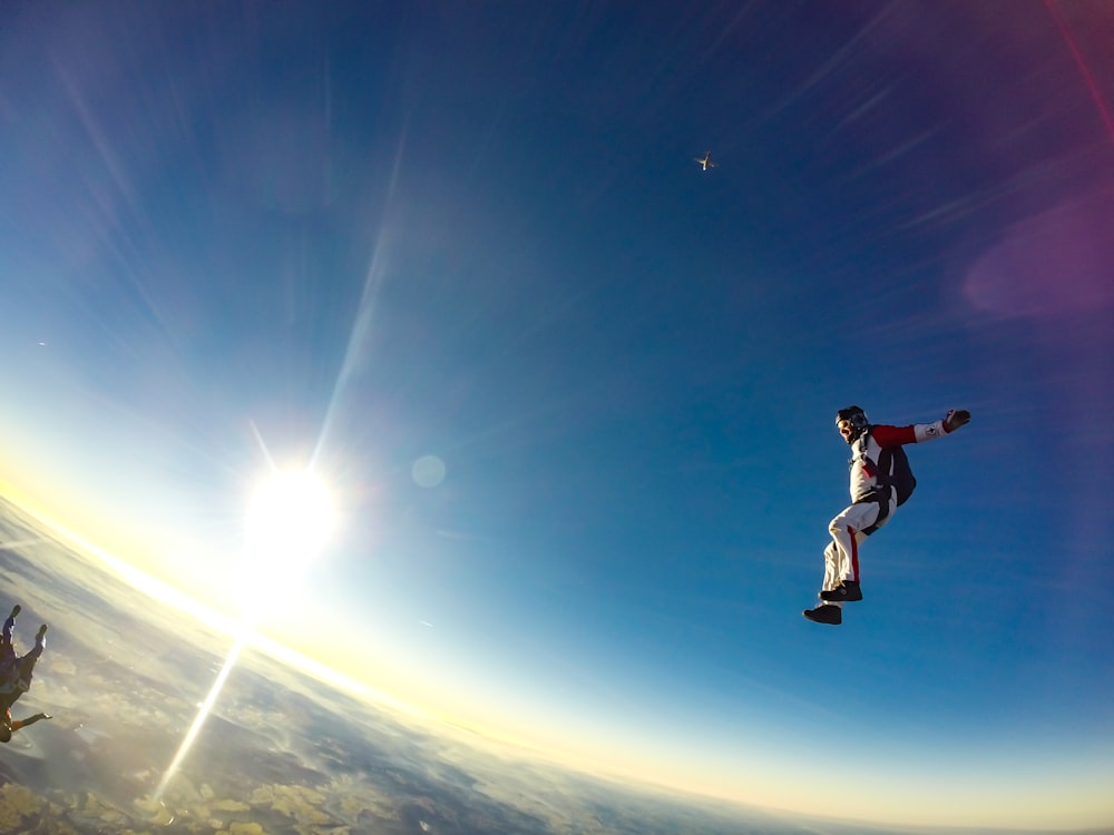 uomo che salta nel cielo durante il giorno