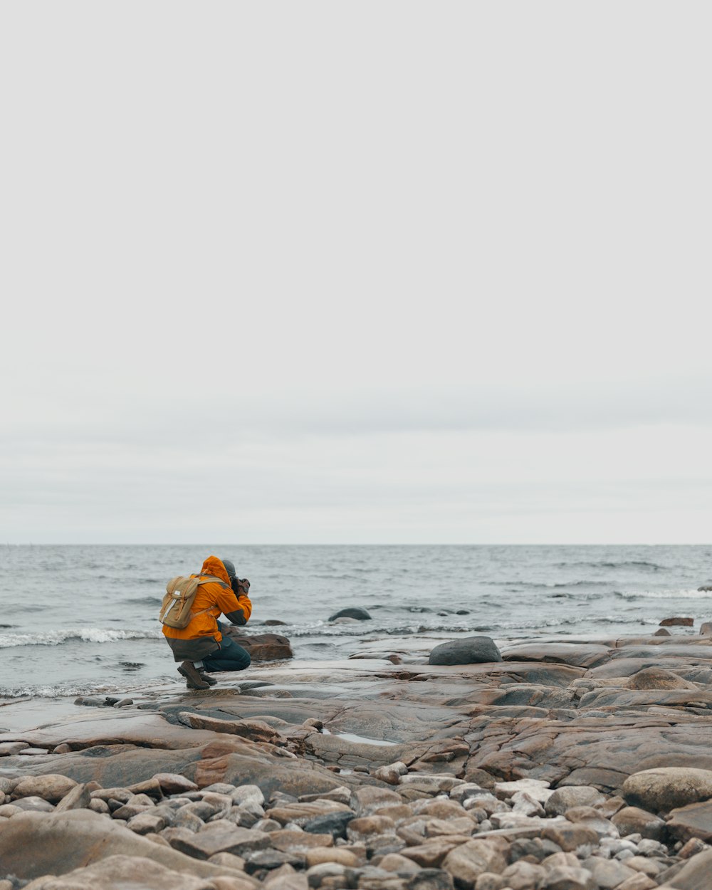 person taking photo of sea waves on beach