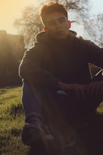 A serene outdoor scene with a person basking in warm sunlight on grass.