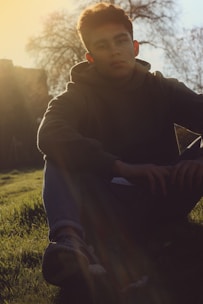 A serene outdoor scene with a person basking in warm sunlight on grass.