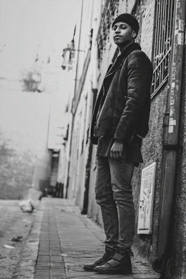 Urban alleyway with bold street art and a lone figure in a black jacket and beanie.
